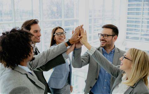 A group of office workers coming together for a high five
