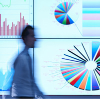 A man walking and looking like a blur with charts in the back ground.